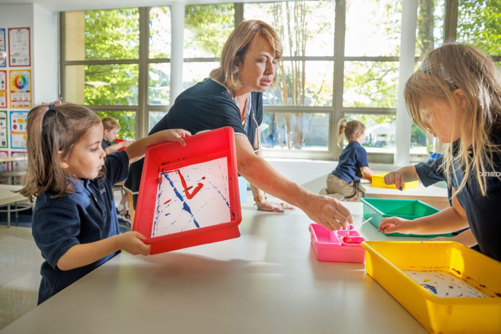PreK4 students painting with their teacher at The School of the Cathedral